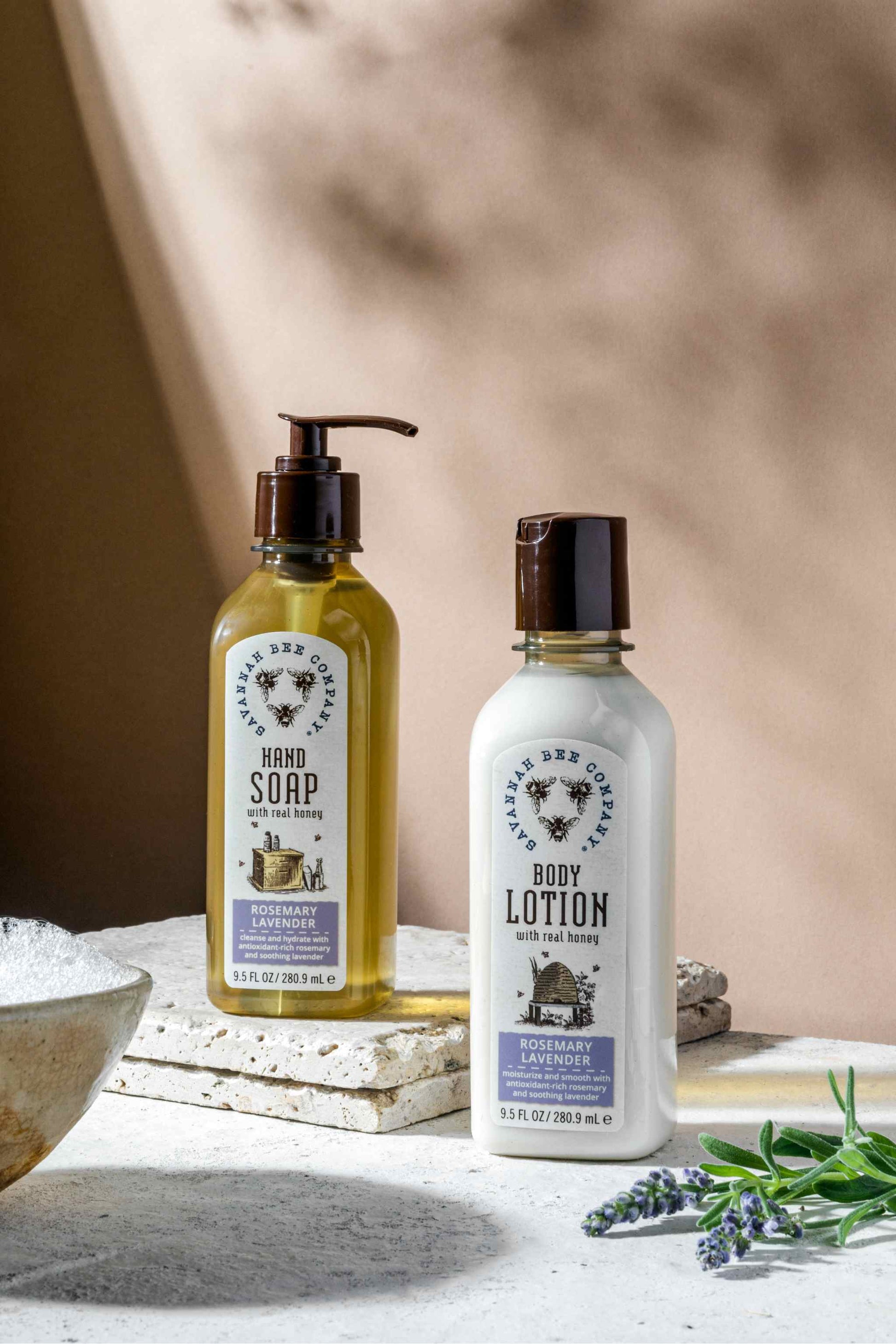 Rosemary Lavender Honey Hand Soap and Rosemary Lavender Body Lotion with lavender sprigs and a bowl of bubbles.