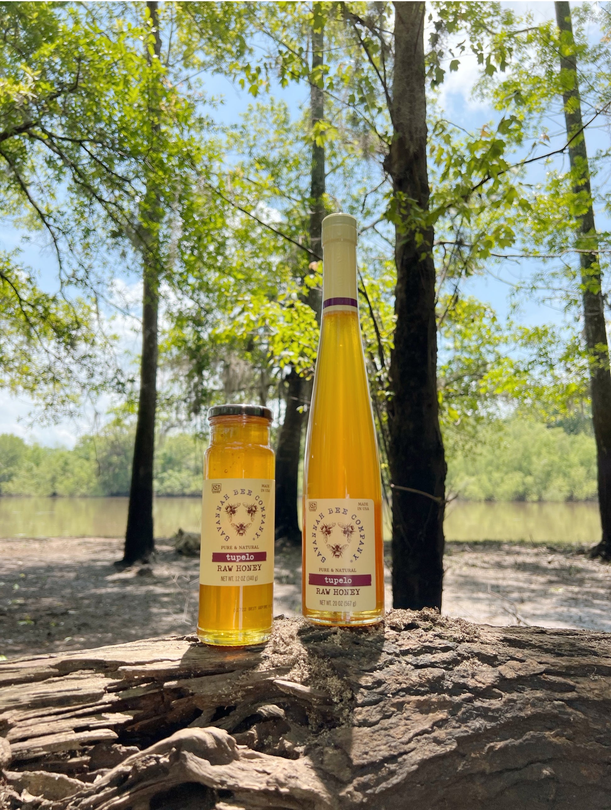 tupelo honey 12oz and tupelo honey 20oz sitting in a tupelo grove